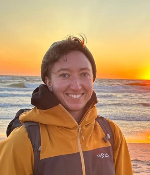 Person smiling with a sunset in the background